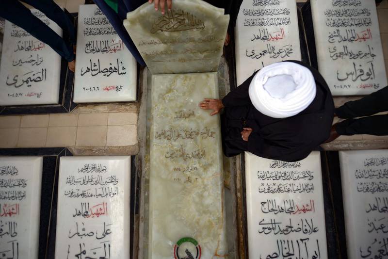 A cleric mourns at the grave of Iraqi paramilitary commander Abu Mahdi Al Muhandis. AFP