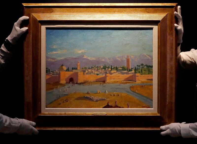FILE - In this Wednesday, Feb. 17, 2021 file photo, Christie's employees adjust an oil on canvas painting by Sir Winston Churchill painted in Jan. 1943 called 'Tower of the Koutoubia Mosque' during an Art pre-sale photo call at Christie's auction house in London. The Moroccan landscape painted by Winston Churchill and owned by Angelina Jolie sold at auction on Monday March 1, 2021, for more than $11.5 million, smashing the previous record for a work by Britainâ€™s World War II leader. (AP Photo/Frank Augstein, File)
