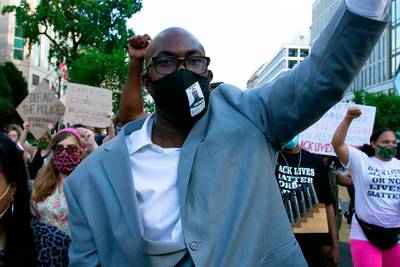 Philonise Floyd (C), George Floyd's brother, holds up his fist as he marches with others on Black Lives Matter Plaza near the White House, to protest police brutality and racism, on June 10, 2020 in Washington, DC.  The brother of George Floyd, whose killing by police sparked worldwide protests against racism, made an emotional plea to the US Congress Wednesday to "stop the pain" and pass reforms that reduce police brutality. Demonstrations are being held across the US following the death of George Floyd on May 25, 2020, while being arrested in Minneapolis, Minnesota. / AFP / Jose Luis Magana
