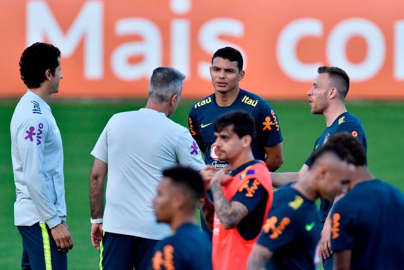 Brazil players Thiago Silva, centre, and Arthur listen to instructions from a member of the coaching staff. AFP