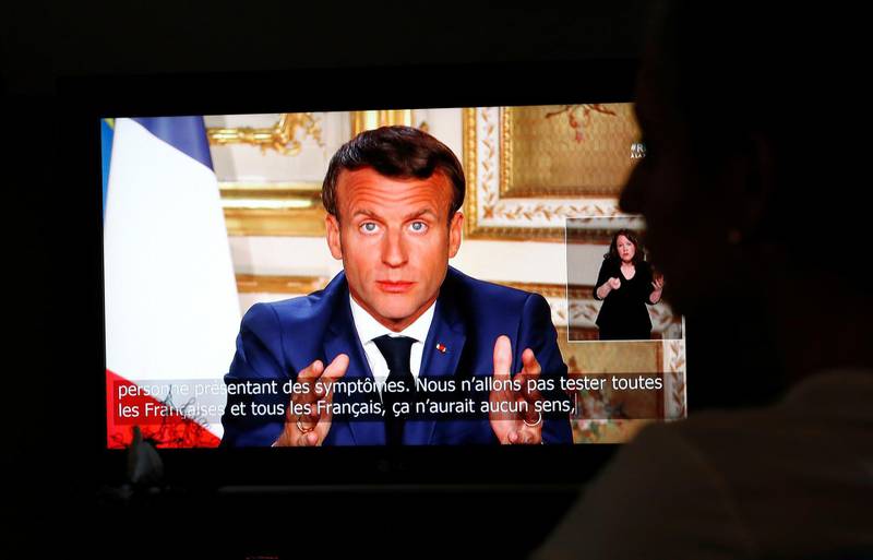 French President Emmanuel Macron is seen as he addresses the nation about the coronavirus disease (COVID-19) outbreak, on a television screen from confined people in Vertou, France, April 13, 2020. REUTERS/Stephane Mahe