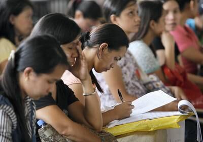 A woman fills an application form for a job posting in Kuwait during a job fair at the Philippine Overseas Employment Agency in Manila in this September 20, 2010 file photo. An average of more than 3,000 workers leave the country daily to work as professionals, nurses, doctors, domestic helpers, seafarers and labourers overseas. The Philippines, the world's fourth biggest recipient of remittances after India, Mexico and China, received more than $1.5 billion worth of remittances monthly from Filipinos working and living overseas. REUTERS/Cheryl Ravelo/Files (PHILIPPINES - Tags: EMPLOYMENT BUSINESS SOCIETY) - GM1E6BJ1JLH01