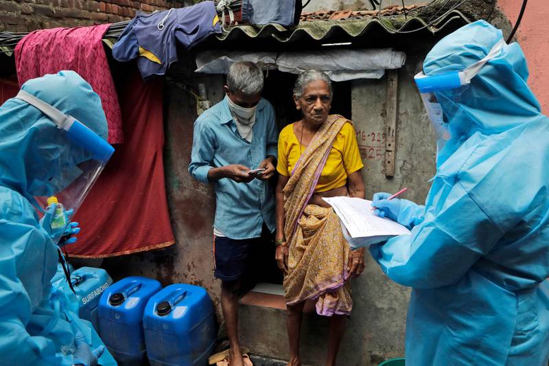 Health workers screen residents for Covid-19 symptoms at Deonar slum in Mumbai, India. AP Photo