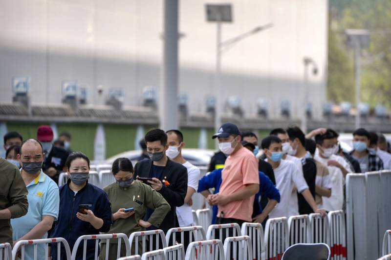People stand in line for Covid-19 tests in Beijing on April 23, one day after 10 infections were detected in middle school students. AP Photo