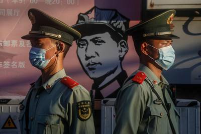 epa08444684 Chinese paramilitary police officers guard beside a portrait of former Chinese leader Mao Zedong in Beijing, China, 26 May 2020..  EPA/WU HONG