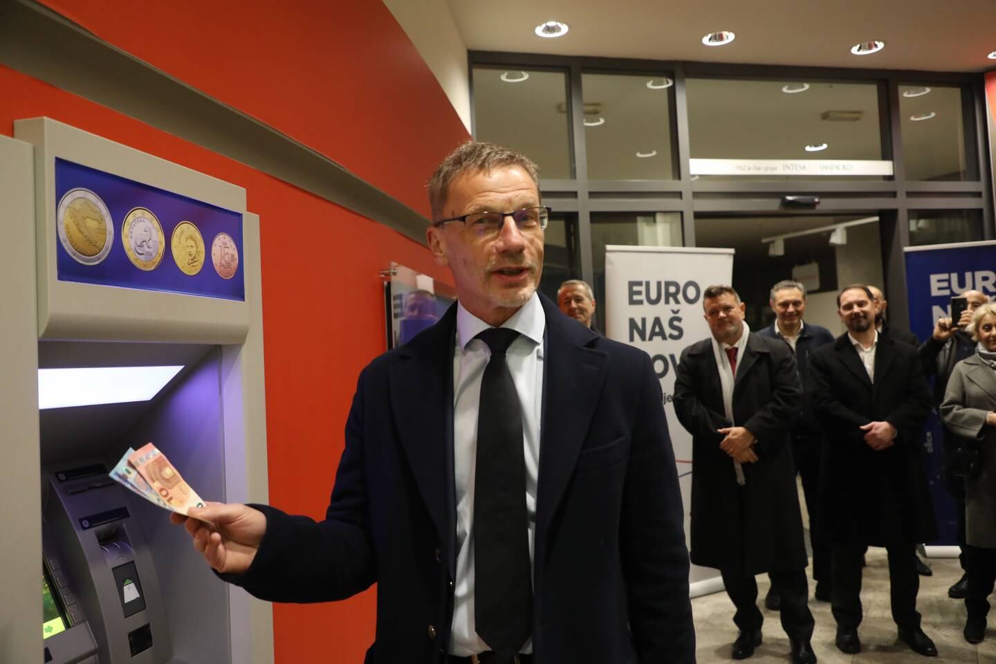 Croatian National Bank Governor Boris Vujcic withdraws euro banknotes at an ATM in Zagreb. EPA