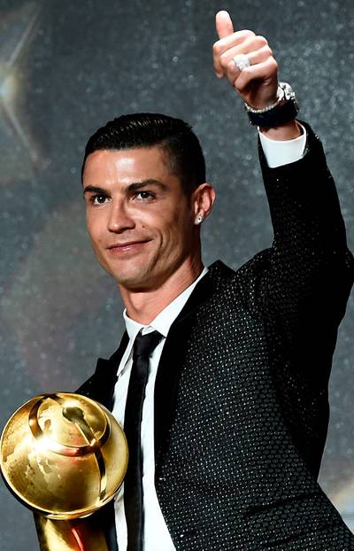 Juventus' Portuguese forward Cristiano Ronaldo celebrates receiving the 433 Fans' Award during the 10th edition of the Dubai Globe Soccer Awards in Dubai.  AFP