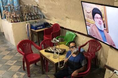 A man smokes a hookah as he watches Lebanon's Hezbollah leader Sayyed Hassan Nasrallah speak on television inside a coffee shop in the port city of Sidon, Lebanon July 12, 2019. Reuters