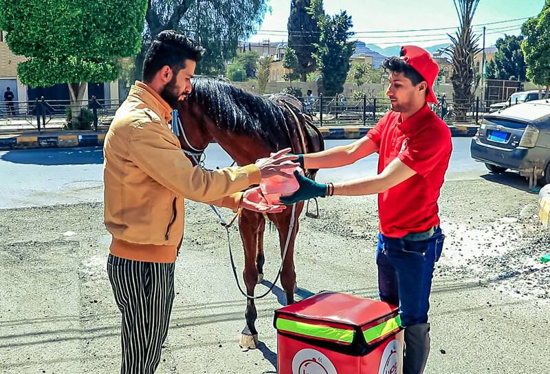 A customer receives a takeaway from the Tawseel food delivery company in Sanaa, Yemen. The difference is that this delivery rider is on horseback. Photo: Tawseel