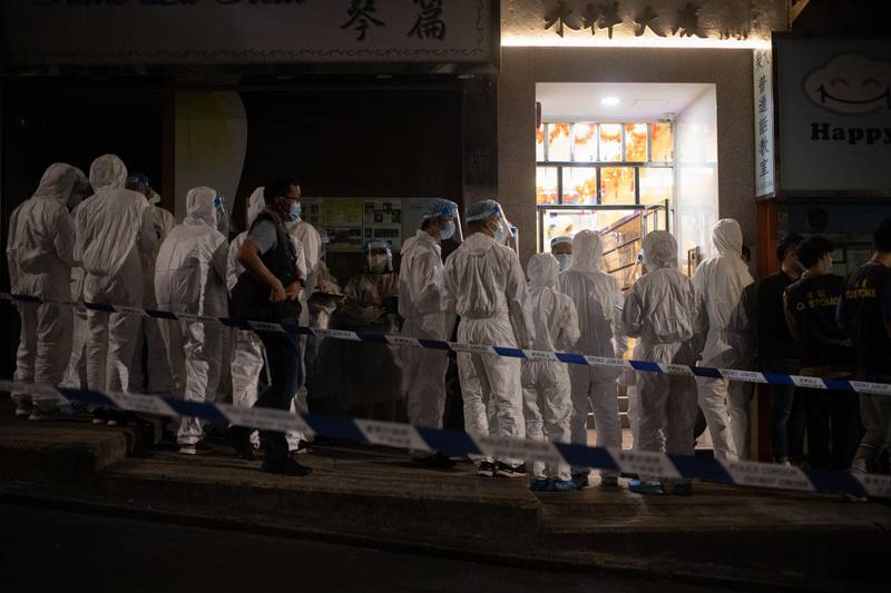 Civil servants in protective gear enter the lobby of a residential building during an 'ambush-style lockdown' in Hong Kong, China. EPA