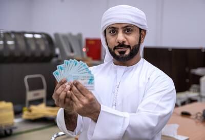 Abu Dhabi, United Arab Emirates, February 10, 2021.  Khaled Al Qubaisi, Quality Control Technician, inspects some newly produced I.D.'s from the printers.Victor Besa/The NationalSection:  NASection:  Nilanjana Gupta