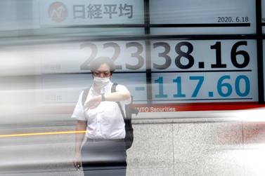 A man stands in front of an electronic stock board at a securities firm  in Tokyo. Typical mistakes investors make include trying to time the market. Associated Press