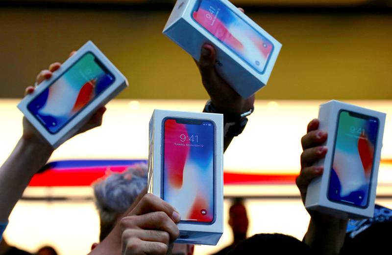 The first customers to buy the iPhone X hold it aloft during the global launch of a new Apple product in Sydney, Australia. Reuters