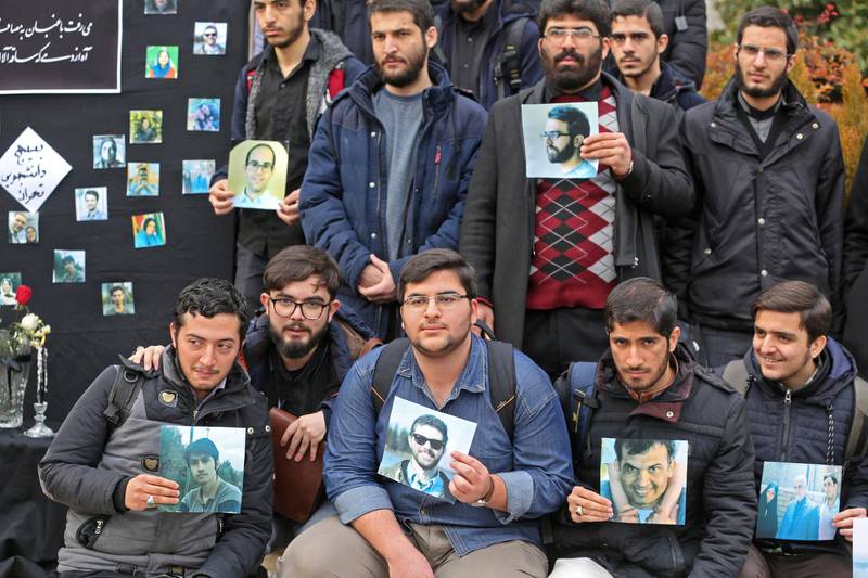 Iranian students hold pictures of victims during a memorial for the passengers of the Ukraine plane crash, in University of Tehran on January 14, 2020. - Iran announced its first arrests over the shooting down of a Ukrainian airliner last week, as it struggles to contain the fallout from the disaster that sparked three days of protests. (Photo by ATTA KENARE / AFP)