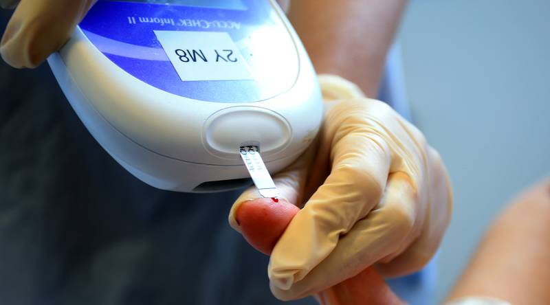 A nurse gives a patient a diabetes test. People with type 2 diabetes suffer more middle-age health problems - and at a younger age - than those without the condition. PA