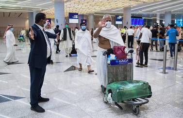 Mask-clad Pakistani travellers arriving to Saudi Arabia to perform the year-round Umrah pilgrimage, walk with their luggage at King Abdulaziz International Airport in the Red Sea coastal city of Jeddah. AFP 