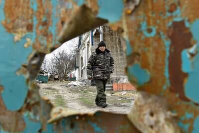 A man walks in his yard, damaged by shelling, in the village of Andriivka, Ukraine. EPA