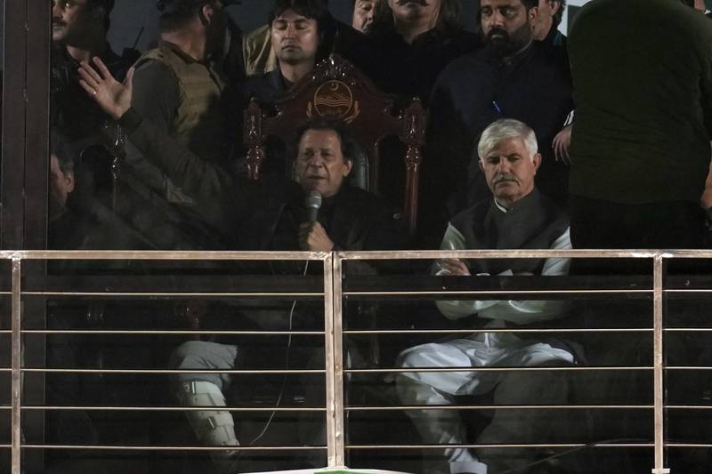Pakistan's former prime minister and opposition leader Imran Khan, centre, was seated as he addressed supporters from behind bulletproof glass. AP