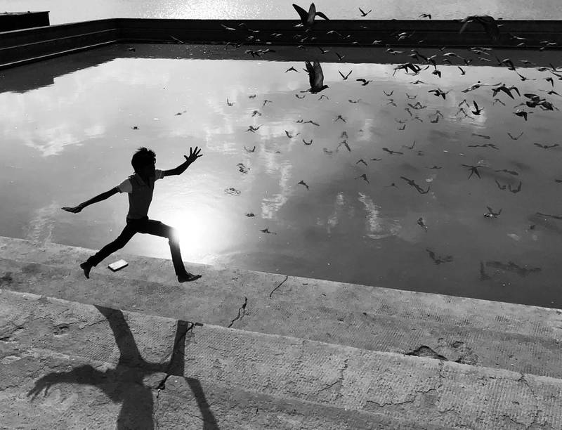 A young boy runs along a lake in India. All images by Dimpy Bhalotia