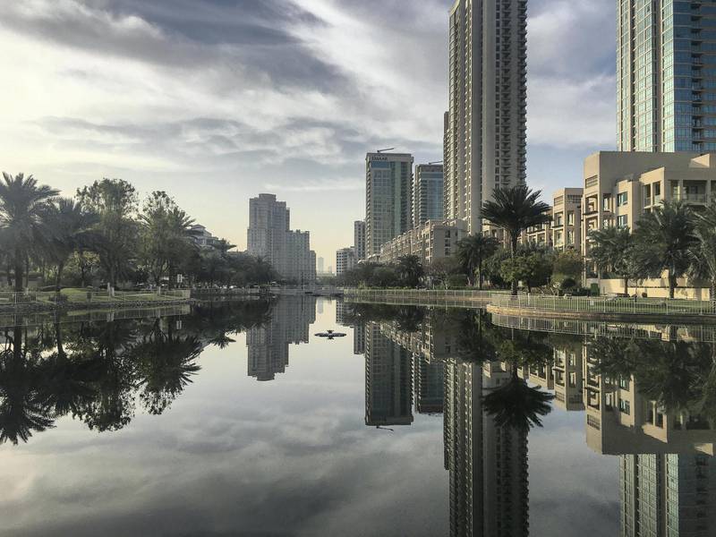 DUBAI, UNITED ARAB EMIRATES. 09 APRIL 2019. Standalone picture of buildings reflected in the water pools of The Greens in Dubai for Weekend Cover. (Photo: Antonie Robertson/The National) Journalist: None. Section: Weekend.