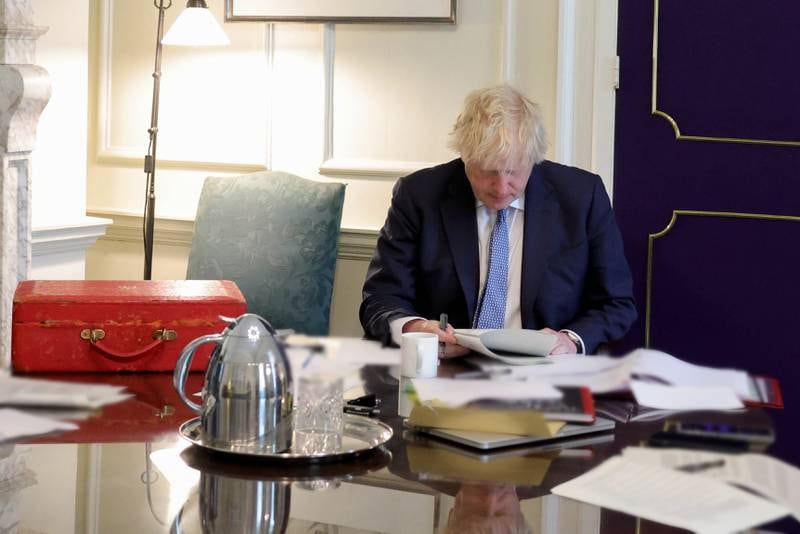 Mr Johnson reads the long-awaited report by senior civil servant Sue Gray into the Downing Street party scandal, in his Downing Street office last month. Photo: Downing Street
