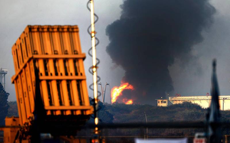 An Iron Dome aerial defence system battery is seen in the foreground as fire rages at Ashkelon's refinery. AFP