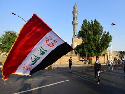 A protester waves the Iraqi national flag during a demonstration at the Al-Firdus square in central Baghdad. EPA