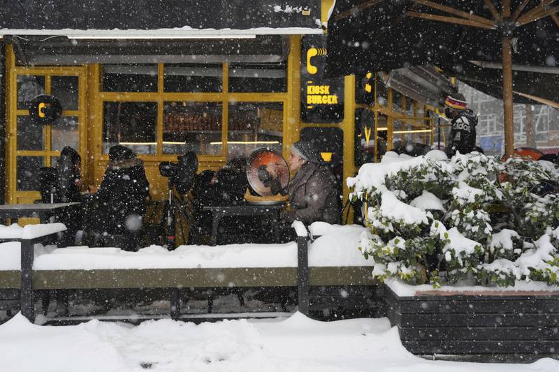The cold does not discourage diners from eating outside a restaurant in Tehran. The weather forced the government to close schools, government offices and private businesses in parts of Iran. AP Photo 