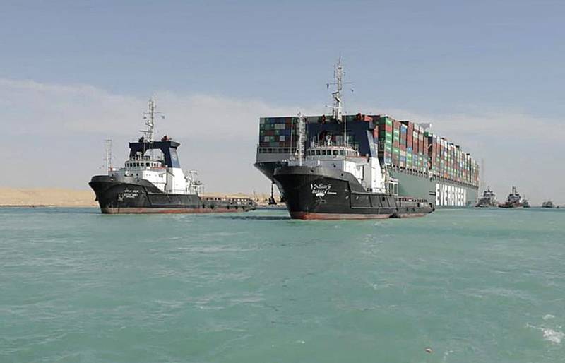 A picture released by Egypt's Suez Canal Authority on March 29, 2021, shows a tugboat pulling the Panama-flagged MV 'Ever Given' container ship after it was fully dislodged from the banks of the Suez. The ship was refloated and the Suez Canal reopened, sparking relief almost a week after the huge container ship got stuck and blocked a major artery for global trade. Salvage crews have been working around the clock ever since the accident which has been blamed on high winds and poor visibility during a sandstorm. / AFP / SUEZ CANAL AUTHORITY / - / == RESTRICTED TO EDITORIAL USE - MANDATORY CREDIT "AFP PHOTO / HO / SUEZ CANAL AUTHORITY" - NO MARKETING NO ADVERTISING CAMPAIGNS - DISTRIBUTED AS A SERVICE TO CLIENTS ==
