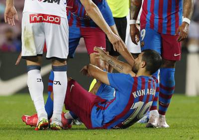 Barcelona's Sergio Aguero goes down after signalling to the bench. Reuters