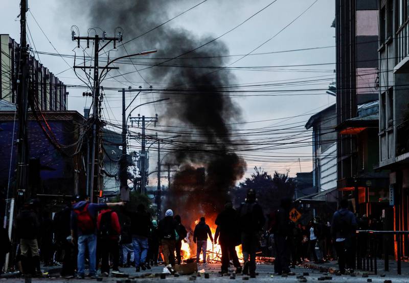 Demonstrators stand next to a burning barricade during anti-government protests, in Concepcion, Chile. Reuters