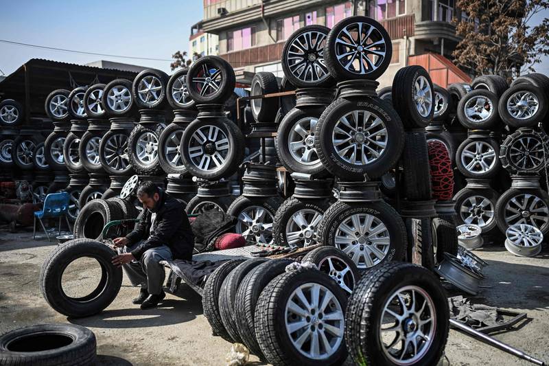 A worker inspects a tyre at a shop in Kabul.  AFP