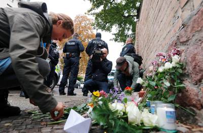 People lay flowers outside the synagogue where congregation barricaded itself inside after the attack started. REUTERS