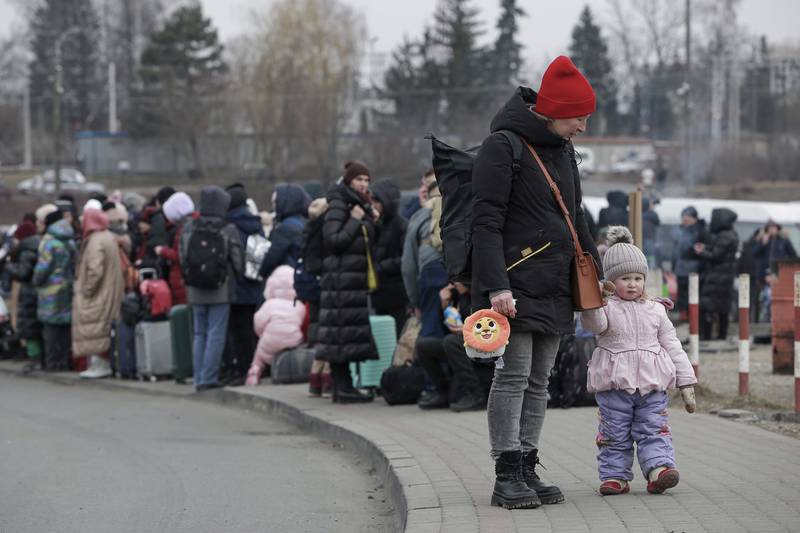 People who fled Ukraine wait for a bus to take them to the train station in Przemysl, at the border crossing in Medyka, Poland. AP Photo