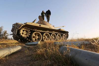 Fighters from the Libya Dawn militia alliance stand on a tank close to the Wetia military air base during clashes with forces loyal to Libya's internationally recognised government on April 28, 2015. Mahmud Turkia/AFP Photo

