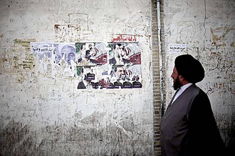 An Iranian clergyman walks past electoral posters of presidential candidates in Qom, some 130 kilometres south of the capital Tehran.