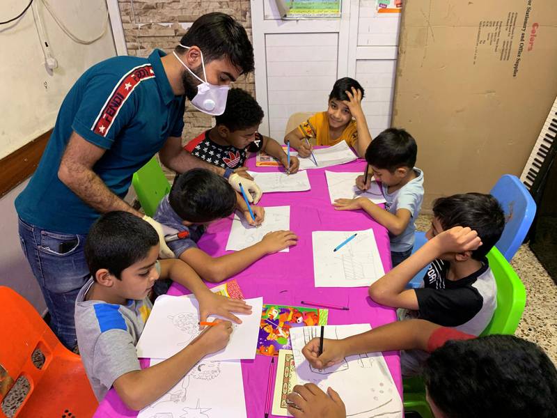 Iraqi orphan children draw in the classroom of an orphanage house during a curfew in Baghdad, Iraq. Reuters