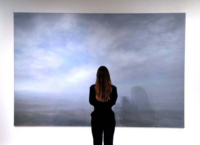 A woman poses in front of Gerhard Richter's 'Seestuck (Seascape)'. AFP