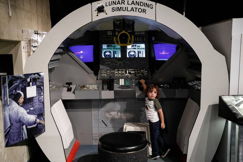 Henry Cook plays inside a Lunar Landing Simulator.