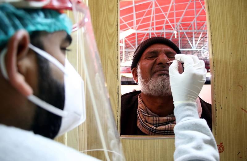 A Pakistani health worker takes a sample to test for Covid-19 during a surge in Omicron cases in Islamabad. EPA
