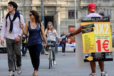 September 27, 2011- A man hands out flyers for an outlet shopping store in Milan, Italy. For Rory Jones story in business Giuseppe Aresu for The National