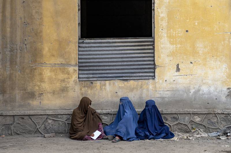 Afghan women wait to receive food rations distributed by a humanitarian aid group, in Kabul. AP Photo 