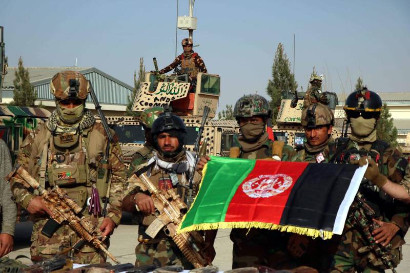 Afghan security officials pose in the Karokh district of Herat after suspected Taliban militants were killed in an attack on Pashtan Dam in Afghanistan on 16 March 2021. At least three Afghan soldiers and eight Taliban militants were killed in the incident. Jalil Rezayee / EPA