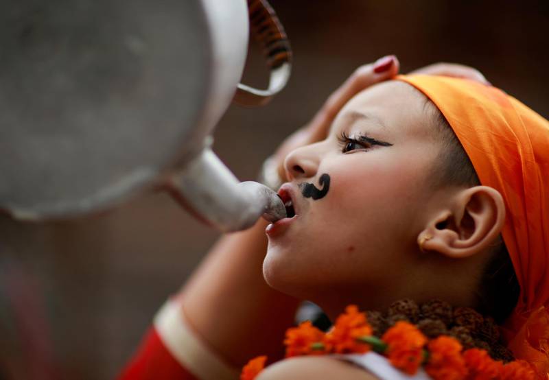 A boy is offered milk during a parade to mark Gaijatra festival in Kathmandu, Nepal. Reuters