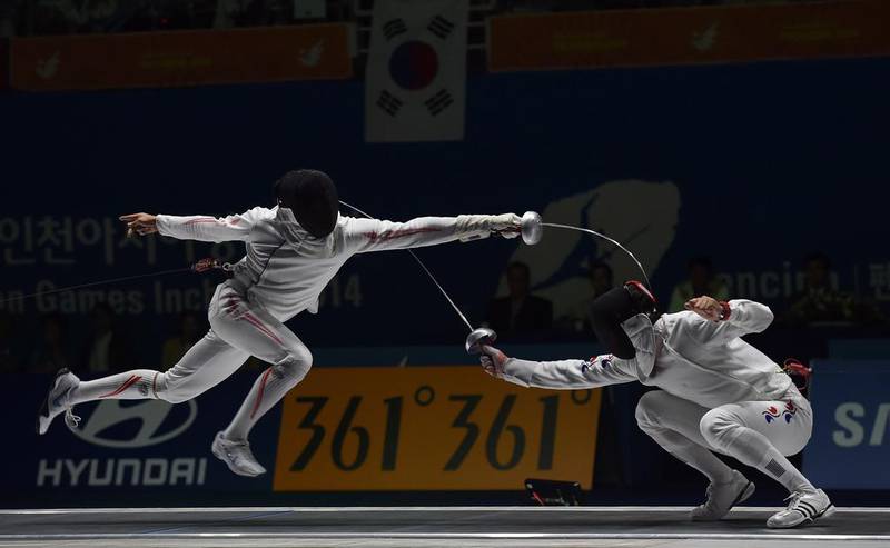 Japan’s Kazuyasu Minobe (L) duels with South Korea’s Jung Jinsun during the men’s epee team fencing finals at Goyang gymnasium during the 2014 Asian Games in Incheon on September 23, 2014. AFP PHOTO/ Prakash SINGH