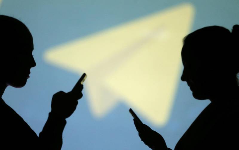 REFILE - CLARIFYING CAPTION Silhouettes of mobile users are seen next to a screen projection of Telegram logo in this picture illustration taken March 28, 2018.  REUTERS/Dado Ruvic/Illustration