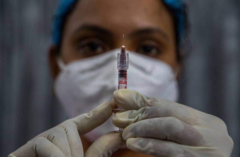 A health worker checks a syringe before performing a trial run of Covid-19 vaccine delivery system in Gawahati, India. AP Photo