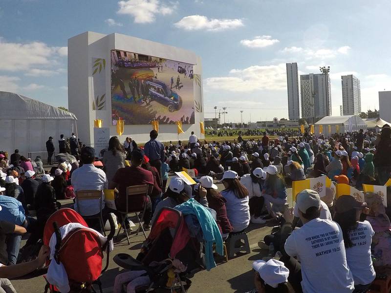 People watching Pope on the screen outside the stadium. Pawan Signh / The National