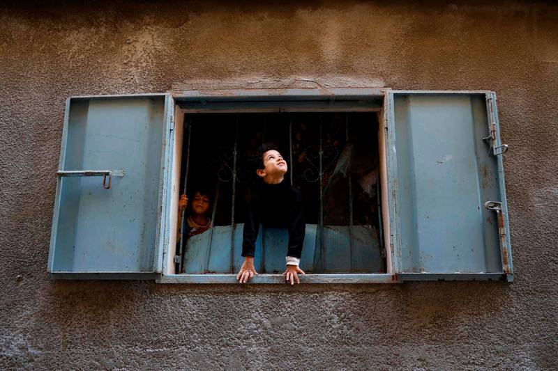 Palestinian boys look out from their family home near the Saint Porphyrios Greek Orthodox Church in Gaza City, which is closed to the public this year due to Covid-19 restrictions. AFP