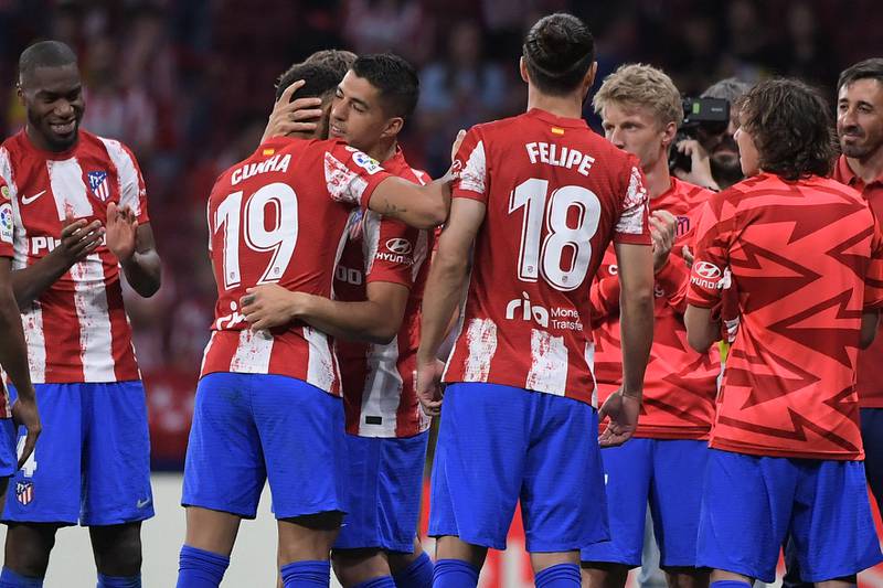 Luis Suarez embraces his Atletico Madrid teammates at the end of the match between Atletico Madrid and Sevilla. AFP